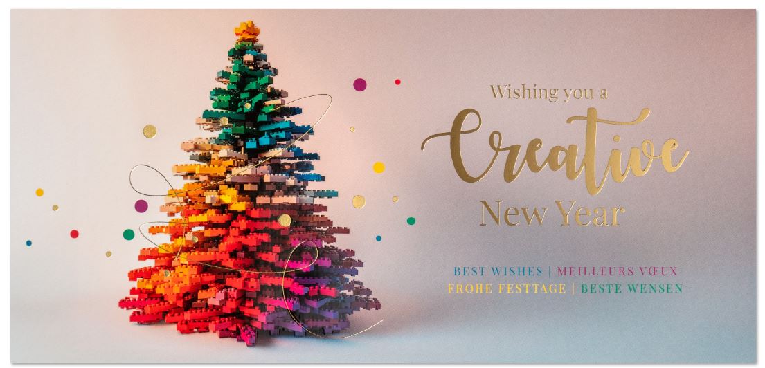 Moderne, internationale Neujahrskarte mit Weihnachtsbaum aus bunten Klemmbausteinen und passendem Slogan