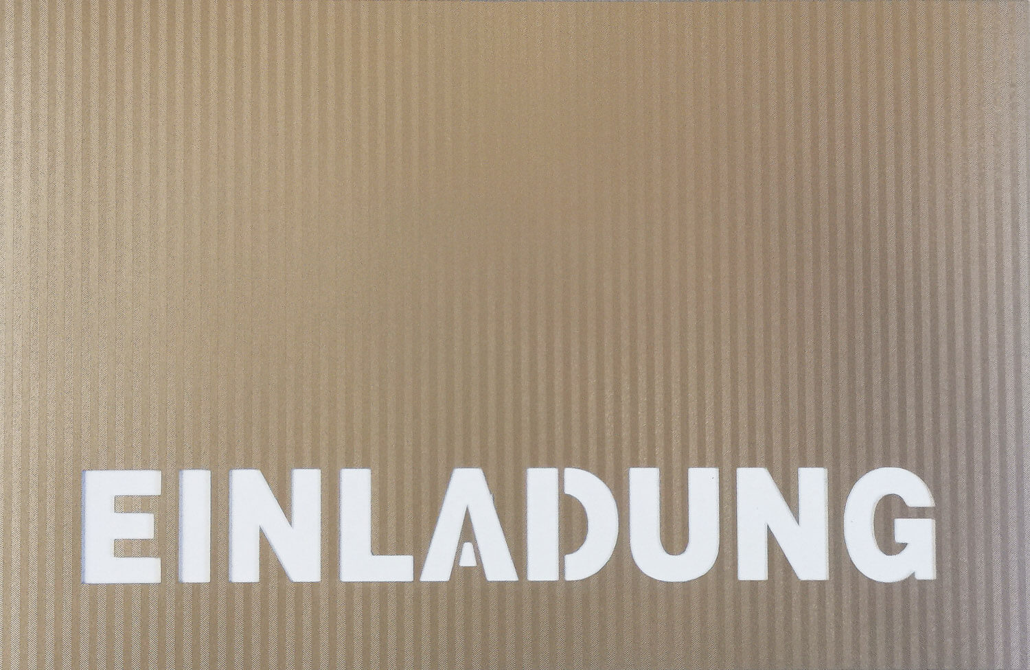 Goldfarbene Einladungskarte mit ausgestanztem Schriftzug "EINLADUNG" und cremefarbenem Einlegeblatt