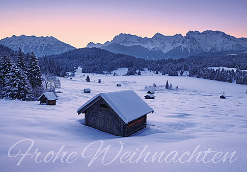Weihnachtskarte mit verschneiten Hütten und Bergen in abendlicher Stimmung