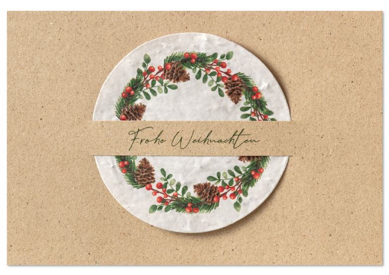 Naturbraune Weihnachtskarte aus Graspapier und eingesteckte Kugel aus Samenpapier mit floralem Kranz