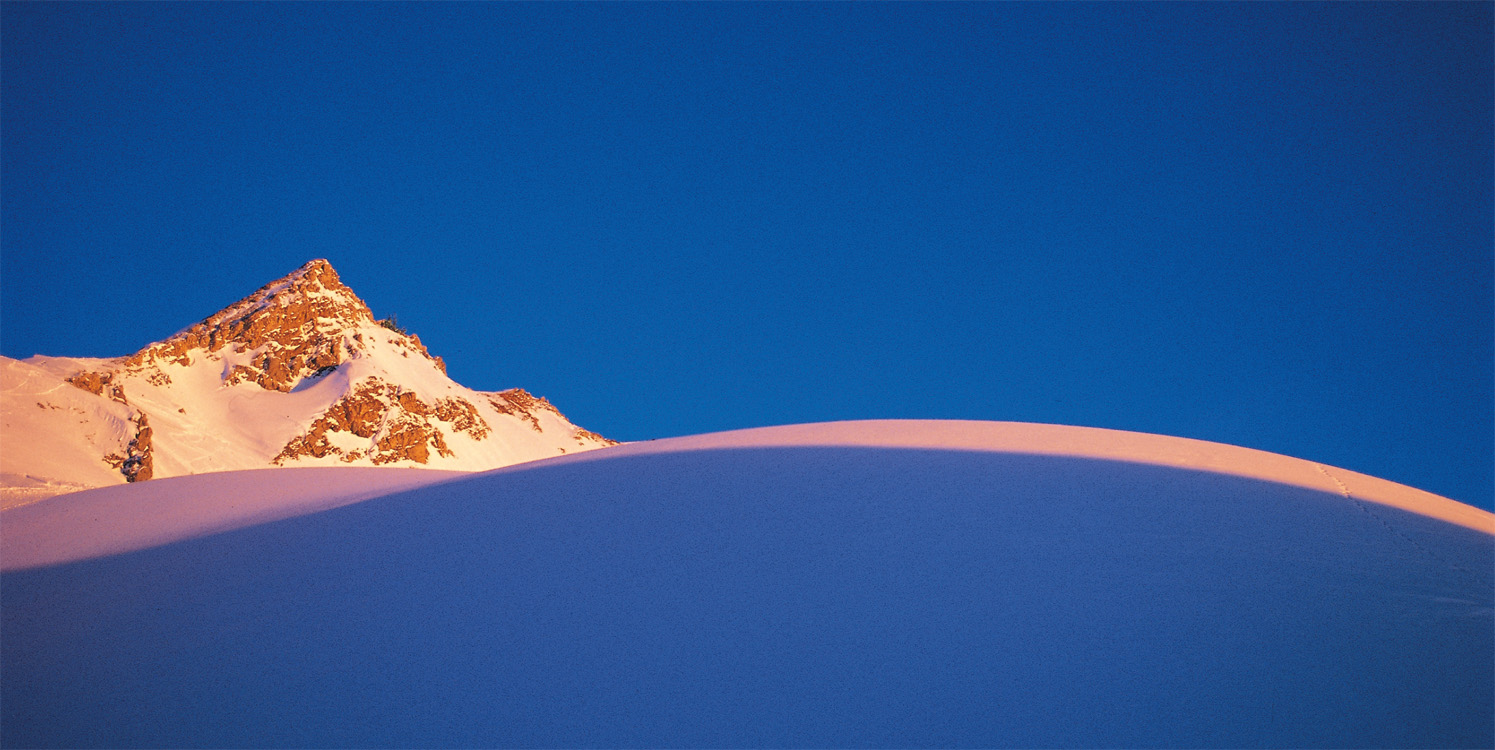 Weihnachtskarte mit verschneitem Gipfel im Sonnenlicht