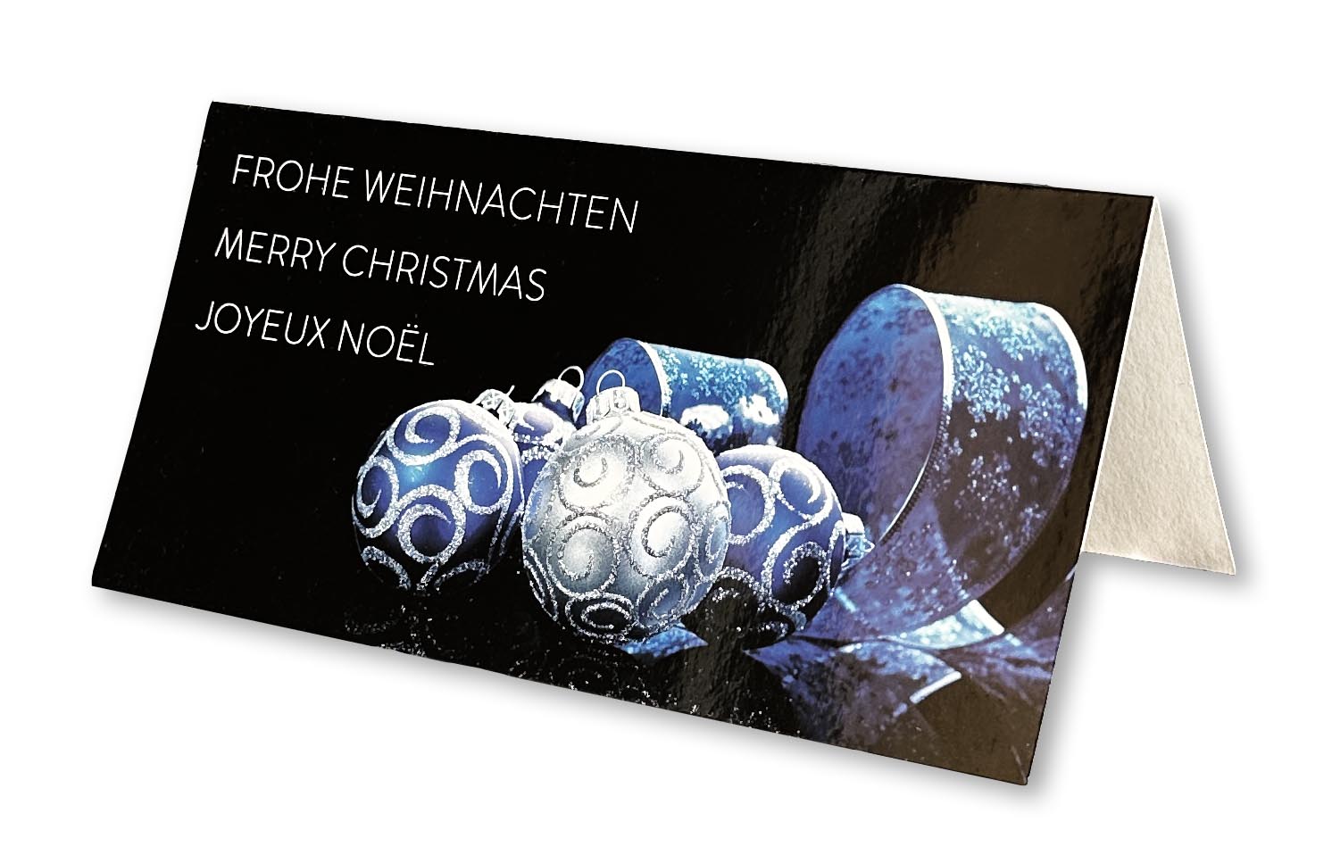 Internationale Grußkarte in schwarz mit blauen Christbaumkugeln, Band und mehrsprachigen Grüßen, DIN lang.