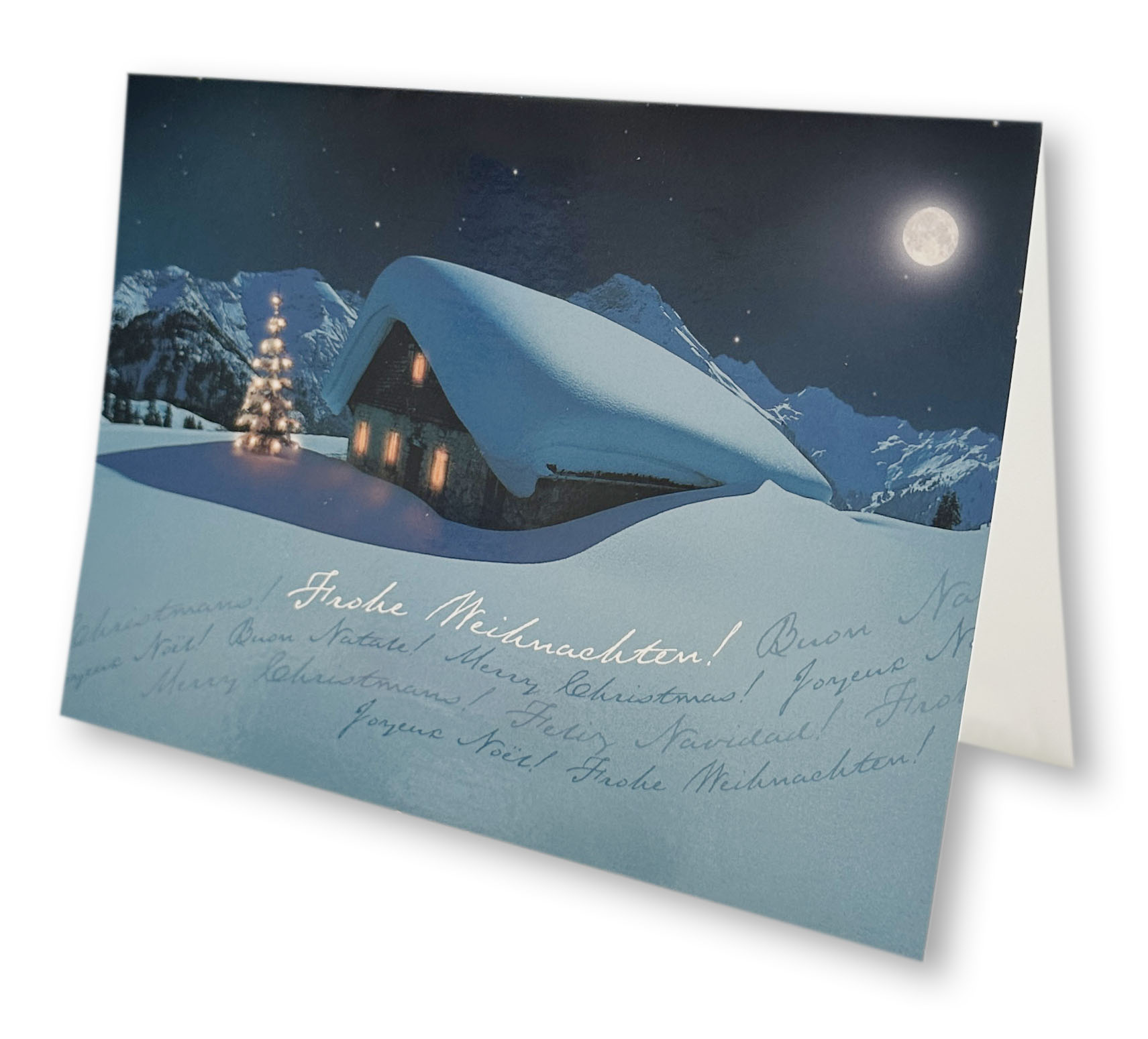Romantische Weihnachtskarte mit verschneiter Berghütte bei Nacht und mehrsprachigen Weihnachtsgrüßen.