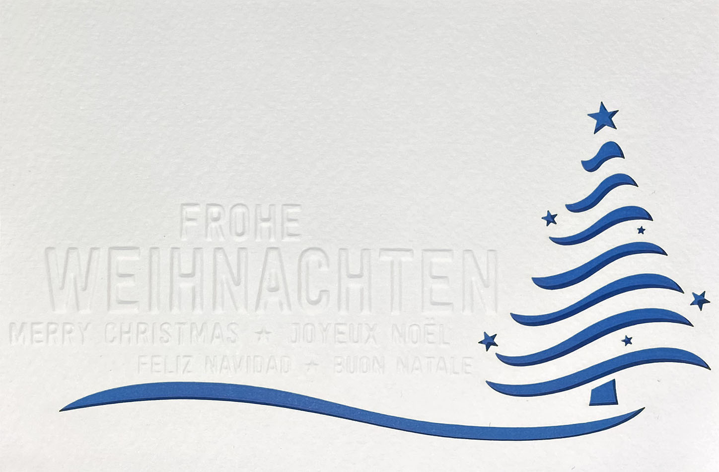 Weiße Weihnachtskarte mit Blindprägung, Formstanzung Baum und blauem Einleger