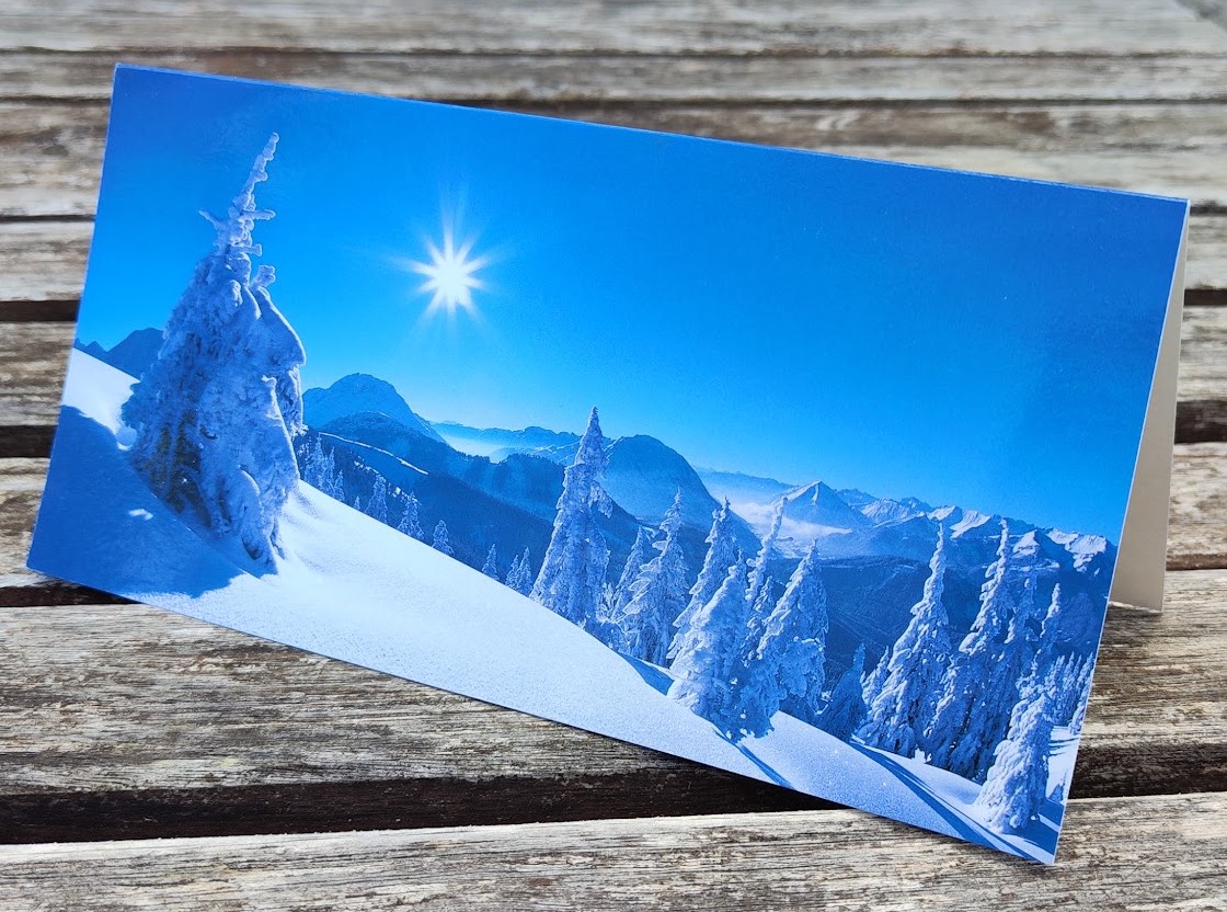 Panoramakarte mit Winterlandschaft in den Bergen bei strahlendem blauen Himmel.