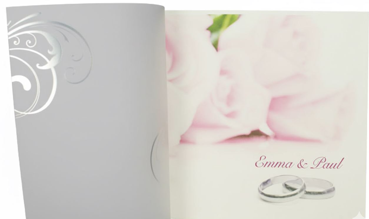 Romantische Einladungskarte zur Hochzeit mit Rosenblüten und Ehringen sowie Kunststoffhülle mit pinkem Ornamentdruck aufgeklappt