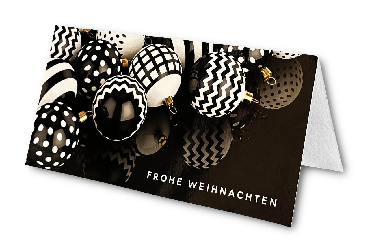 Weihnachtskarte schwarz-weiß mit modernen Christbaumkugeln auf schwarz-glänzendem Untergrund, DIN lang.